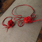 Collier artisanal rose rouge et plumes .